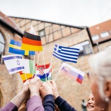 Hochschulvertreter:innen halten Fähnchen mit den Flaggen verschiedener europäischer Länder