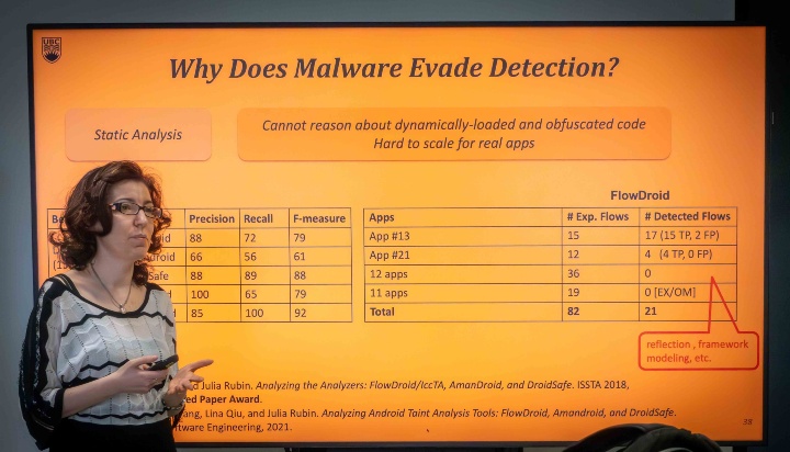 Julia Rubin spricht vor Videowand mit Slide "Why Does Malware Evade Detection?".