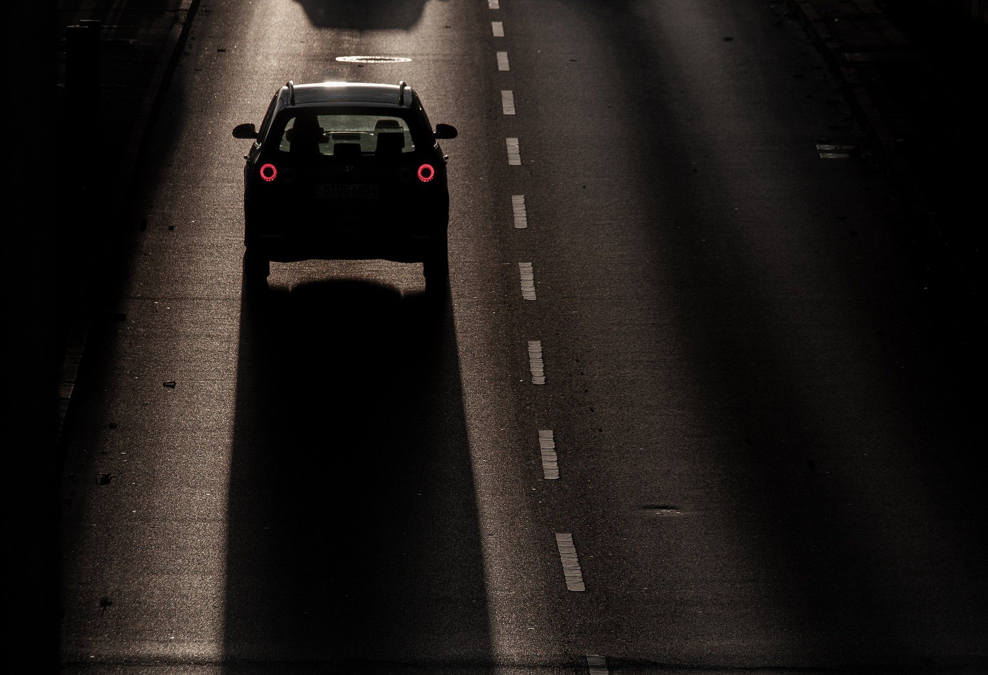 Rückseite eines Autos auf Straße im Gegenlicht.