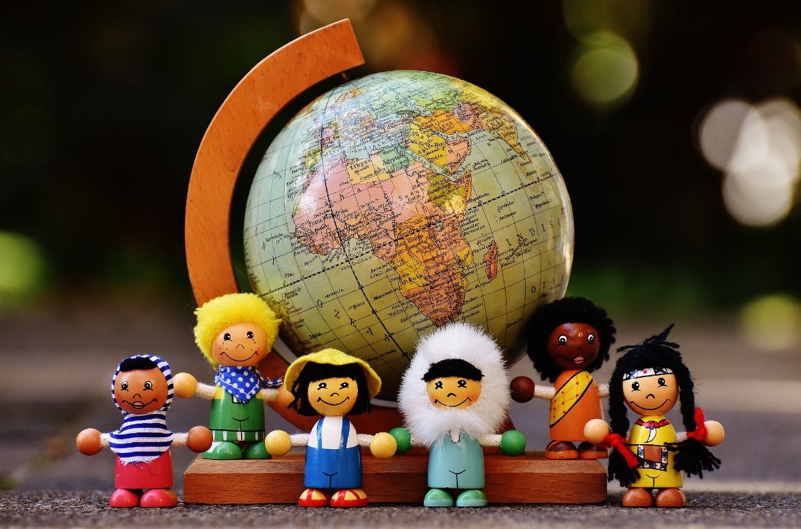 Globus, davor Puppen mit stereotypen Nationalitäten